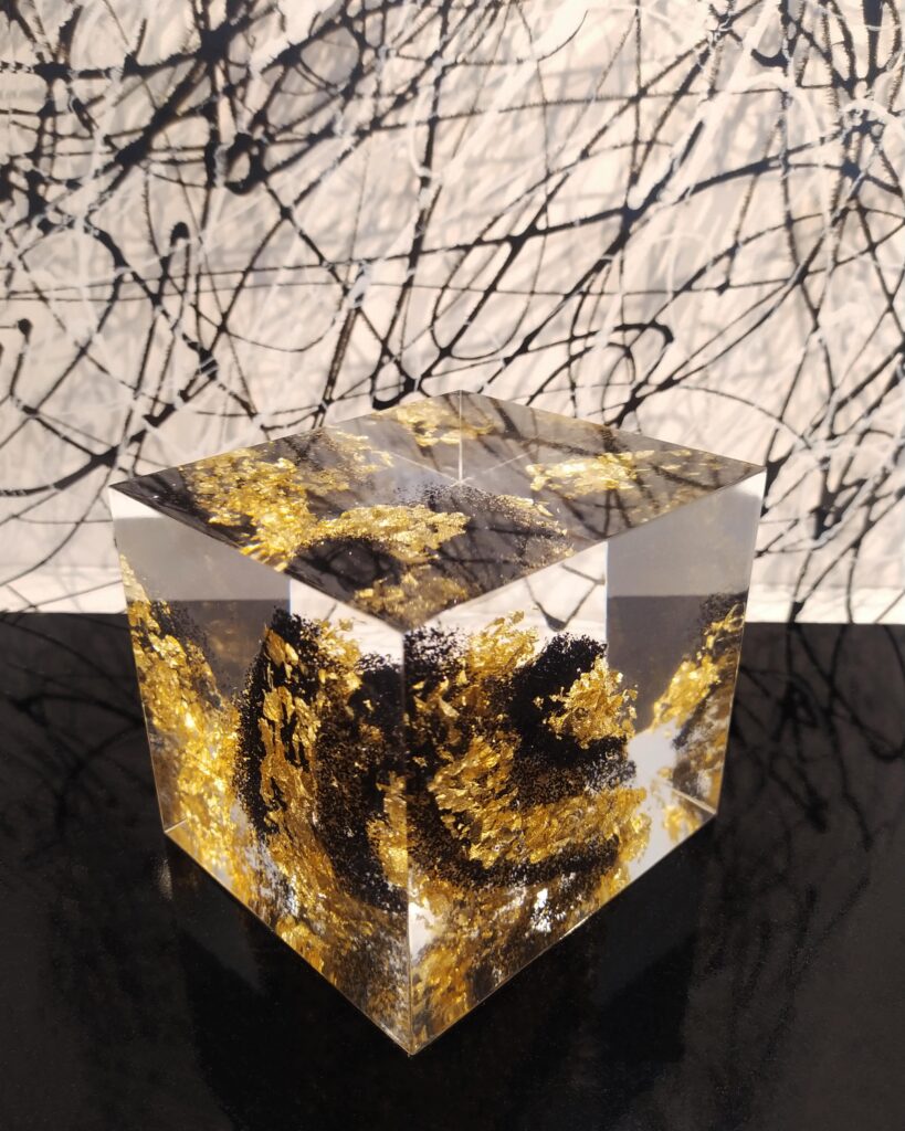 Cube avec une spirale mêlant paillettes noires et feuille d'or
